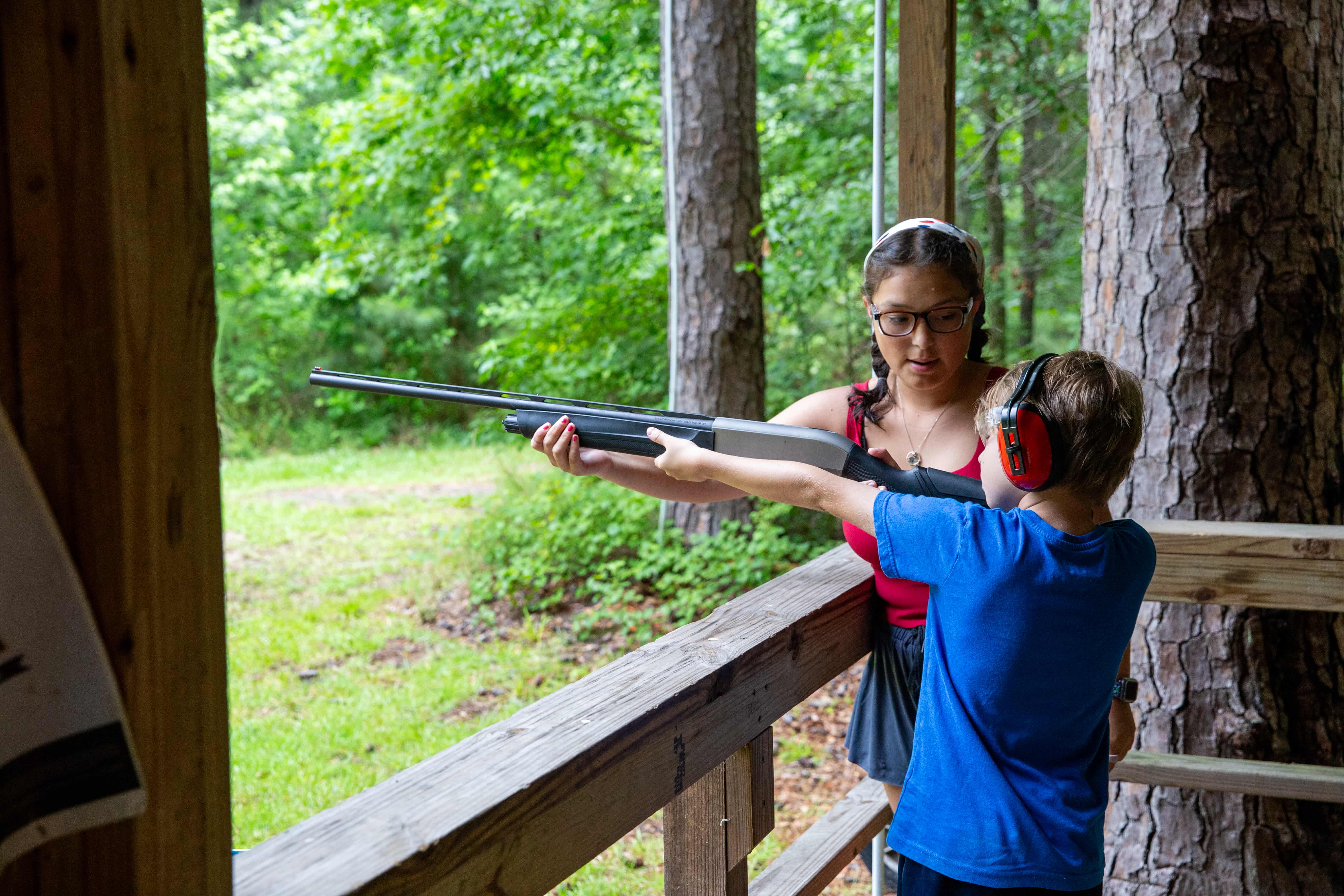 child shooting a bow and arrow at summer camp
